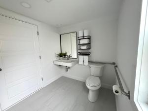 ein Badezimmer mit einem WC, einem Waschbecken und einem Spiegel in der Unterkunft Kingfisher Harwich Port in Harwich Port