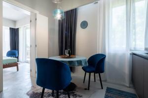 uma sala de jantar com cadeiras azuis e uma mesa em Officine Cavour - Appartamenti la Quercia em Pádua