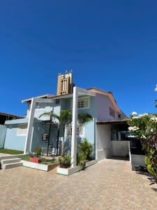 una casa blanca con palmeras delante en Pousada Encanto dos Mares en Natal