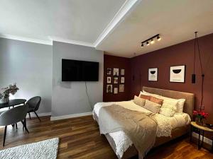 a bedroom with a bed and a television on a wall at Spacious studio for 4 near Regents Park n1 in London