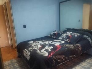 Un dormitorio con una cama con una manta de fútbol. en DEPARTAMENTO CERCA DE PERINORTE, en Tultitlán