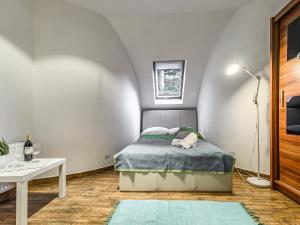 a small bedroom with a bed and a table at VisitZakopane - White Valley Apartment in Zakopane