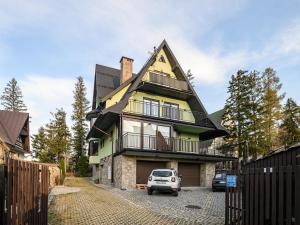 a house with a car parked in front of it at VisitZakopane - White Valley Apartment in Zakopane