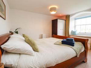 a bedroom with a bed with white sheets and a window at 9 Bell Busk in Skipton