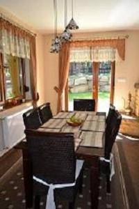 a dining room with a wooden table and chairs at Domek Letniskowy Leśna Chata in Szklarska Poręba