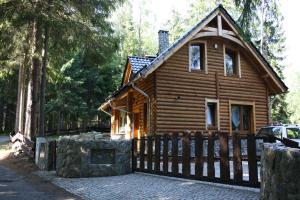 a log cabin with a fence in front of it at Domek Letniskowy Leśna Chata in Szklarska Poręba