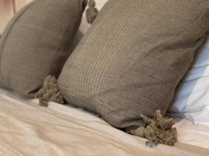 uma almofada sentada em cima de uma cama em Ophelia Tulum Condo Hotel in Aldea Zama em Tulum