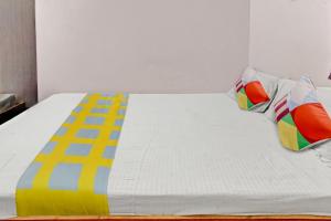 un letto con cuscini colorati sopra di Super OYO Hotel Happy Inn a Patna
