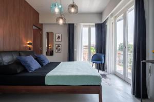 a bedroom with a bed and a large window at Officine Cavour - Appartamenti la Quercia in Padova