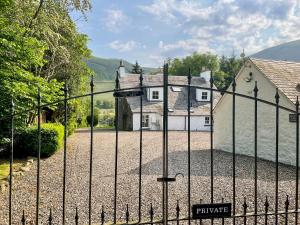 an iron gate in front of a house at The Old Manse - Ukc6854 in Millton of Clova