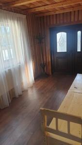a living room with a door and a wooden floor at Casă privată in Rozavlea
