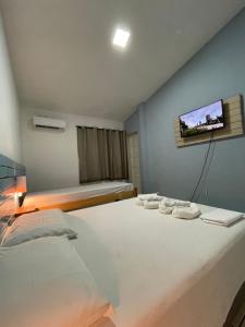 納塔爾的住宿－Pousada Encanto dos Mares，卧室配有一张床,墙上配有电视。