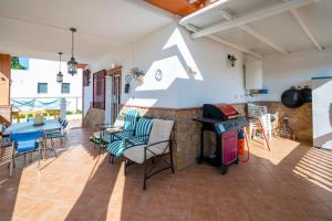 eine Terrasse mit einem Herd, einem Tisch und Stühlen in der Unterkunft Villa Entre dos Tierras in Otura