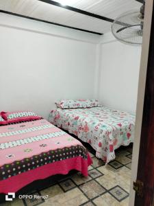 2 camas en una habitación con paredes blancas en Donde Salito, en Norcasia