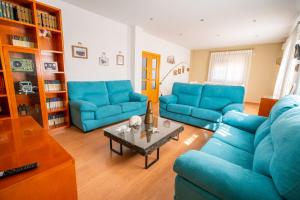 ein Wohnzimmer mit blauen Sofas und einem Couchtisch in der Unterkunft Villa Entre dos Tierras in Otura