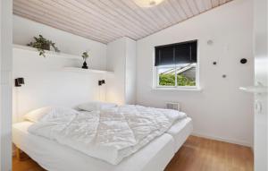 een witte slaapkamer met een bed en een raam bij 3 Bedroom Awesome Home In Juelsminde in Sønderby