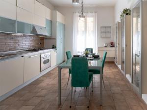 a kitchen with a dining table and green chairs at [Stazione SMN]Art House Florence in Florence