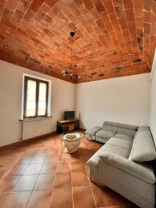 - un salon avec un canapé et une table dans l'établissement Le volte in Toscana, à Bettolle