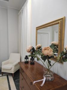 a vase of flowers on a dresser with a mirror at Interno 12 - L'Aquila in LʼAquila