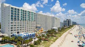 Blick auf ein Resort mit Strand und Gebäuden in der Unterkunft Crown Reef Beach Resort and Waterpark in Myrtle Beach