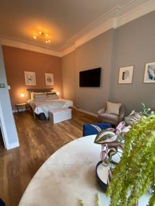 a bedroom with a bed and a couch and a tv at Stylish Studio for 2 near Regents Park n4 in London