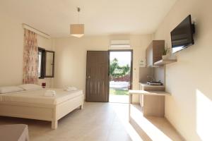 Schlafzimmer mit einem Bett, einem TV und einer Tür in der Unterkunft Asterias in Skyros