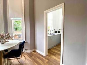 eine Küche mit einem Tisch, einem Waschbecken und einem Fenster in der Unterkunft Stylish Studio for 2 near Regents Park n4 in London