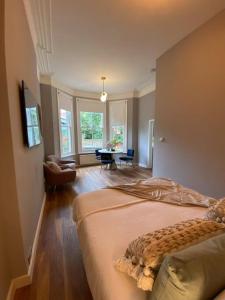 a bedroom with a bed and a living room with a table at Stylish Studio for 2 near Regents Park n4 in London