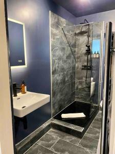 ein Bad mit einer Dusche und einem Waschbecken in der Unterkunft Stylish Studio for 2 near Regents Park n4 in London