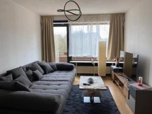 Schöne, möblierte Wohnung mit Balkon und Tiefgarage في دوسلدورف: غرفة معيشة مع أريكة وطاولة