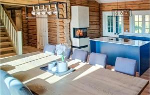 a kitchen and dining room with a table and a fireplace at Awesome Home In Noresund With Sauna, Wifi And 5 Bedrooms in Noresund