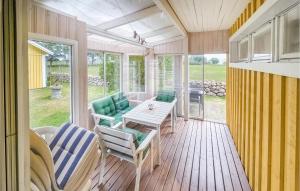 a screened in porch with a table and chairs at Stunning Home In Lttorp With 2 Bedrooms in Löttorp