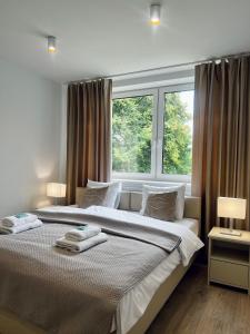 a bedroom with a large bed with a window at Apartamenty Modrzewiowa Zator in Piotrowice