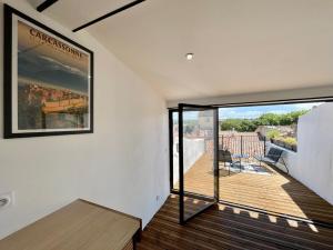 a room with a balcony with a large glass door at Rooftop N°38 - Rooms et Studios - Vue Cité Médiévale in Carcassonne