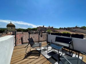 a balcony with a bench and chairs on a roof at Rooftop N°38 - Rooms et Studios - Vue Cité Médiévale in Carcassonne