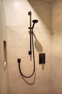 a shower in a bathroom with a hose at Wäller Haus - Modern villa with fireplace & large natural garden in Breitscheid