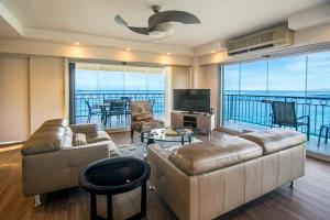 uma sala de estar com um sofá e uma televisão em Waikiki Shore by OUTRIGGER - Select Your Unit em Honolulu