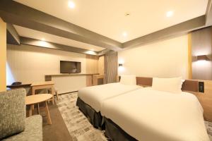 ein Hotelzimmer mit einem großen Bett und einem Stuhl in der Unterkunft Richmond Hotel Narita in Narita