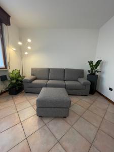sala de estar con sofá y reposapiés en Appartamenti HERA, en Lazise