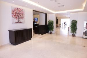 Dolphin Continental Hotel في الكويت: لوبي بالنباتات ولوحة على الحائط