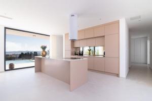 a white kitchen with a counter and a large window at Villa Aurum in Zadar