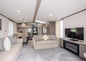 a living room with a couch and a tv at Riverview Holiday Park in Newcastleton
