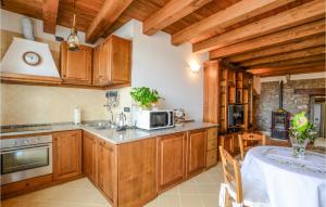 a kitchen with wooden cabinets and a table in it at 3 Bedroom Cozy Home In Comano in Comano