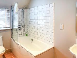 een badkamer met een bad, een toilet en een wastafel bij Brandy Cottage - Ukc6855 in Millton of Clova