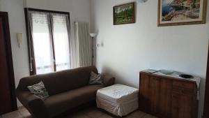 ein Wohnzimmer mit einem braunen Sofa und einem Tisch in der Unterkunft Casa Emily in Fano