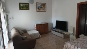 ein Wohnzimmer mit einem Sofa und einem TV in der Unterkunft Casa Emily in Fano