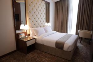 Dolphin Continental Hotel في الكويت: غرفة الفندق بسرير ومرآة