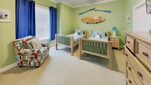 a baby nursery with a crib and a chair at Tranquil Hideaway 4 Bdrm Condo in Avian Forest in Pawleys Island