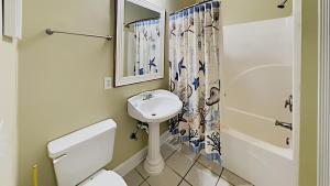 a bathroom with a sink and a toilet and a shower at Tranquil Hideaway 4 Bdrm Condo in Avian Forest in Pawleys Island +5 photos