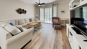 a living room with a couch and a tv at Tranquil Hideaway 4 Bdrm Condo in Avian Forest in Pawleys Island